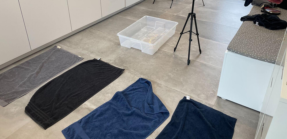 Op de foto zie je de handdoeken op de grond en de set-up van de test. De handdoeken gaan hierna in een bak met water