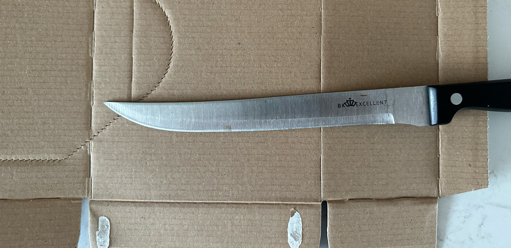 Een mes op een kartonnen doos.